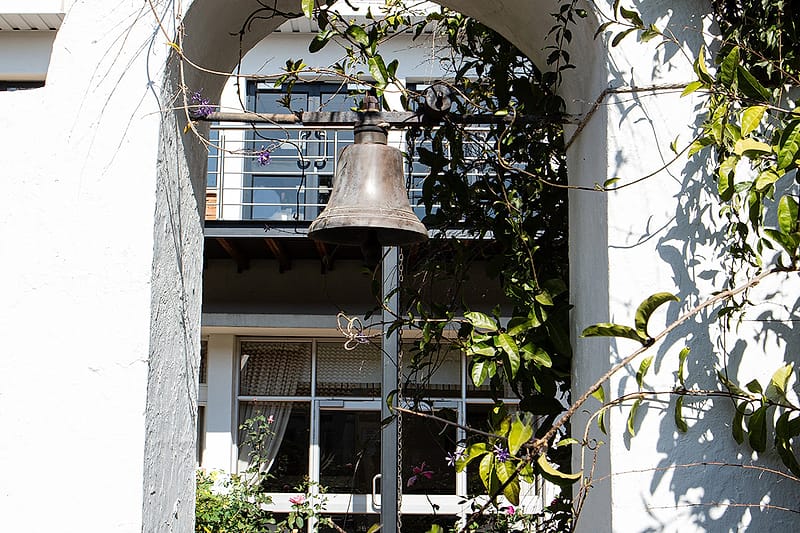The original bell hanging in the whitewashed gable arch.