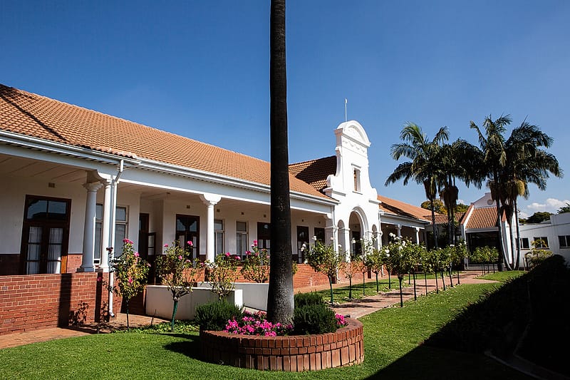 The garden walk outside Zuid-Afrikaans Hospital, with the bell tower beyond.