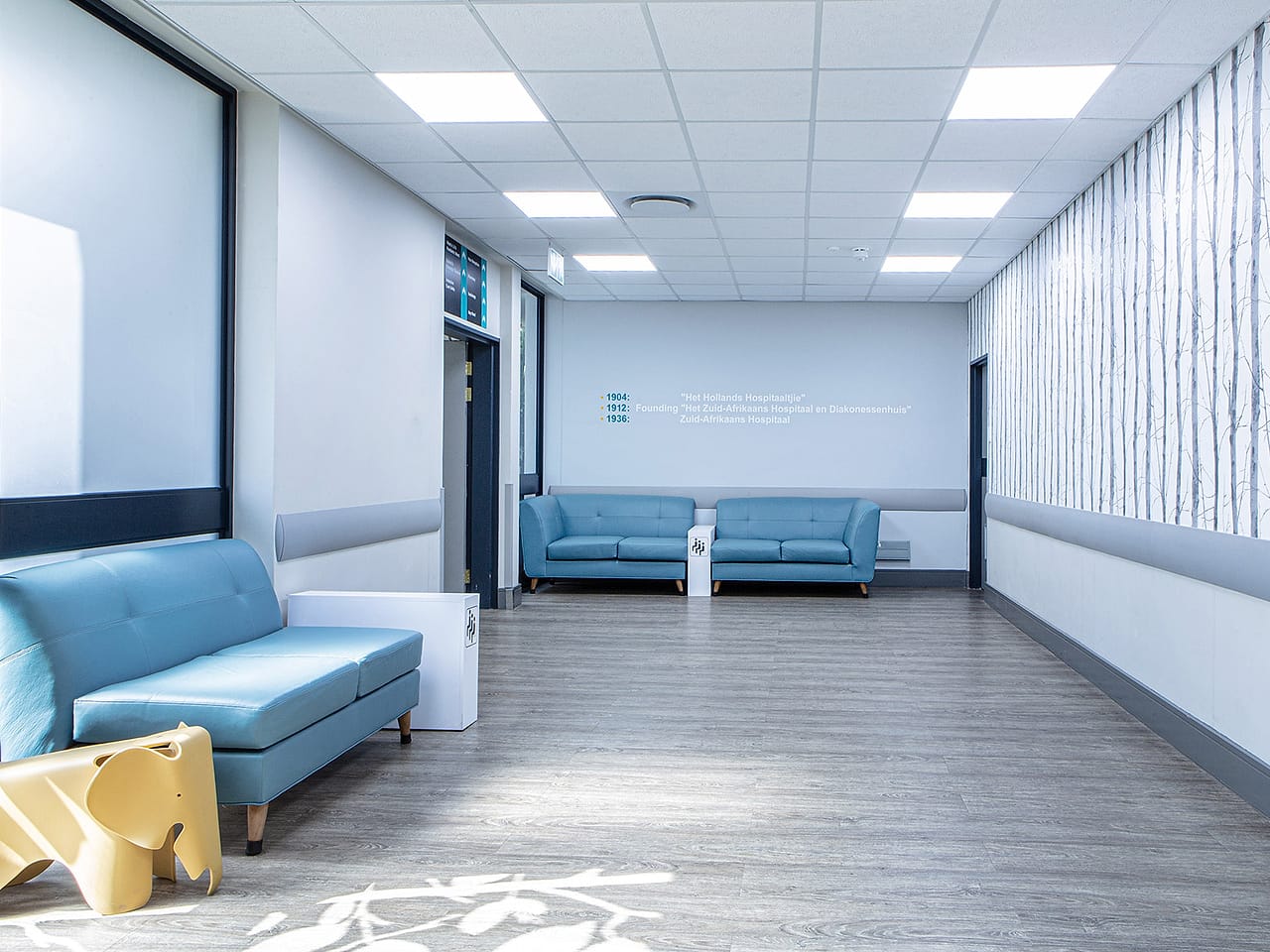 A light-filled family lounge on the ward, with soft seating beside a window.