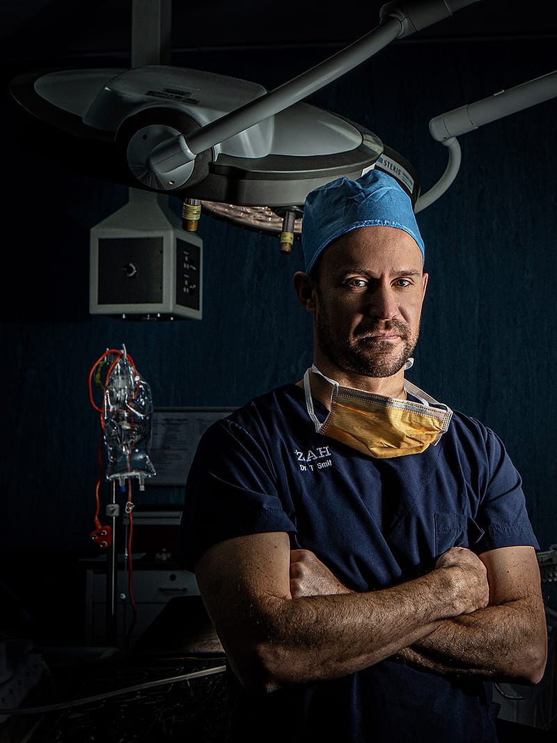 A member of the surgical team photographed in the operating theatre, arms folded.