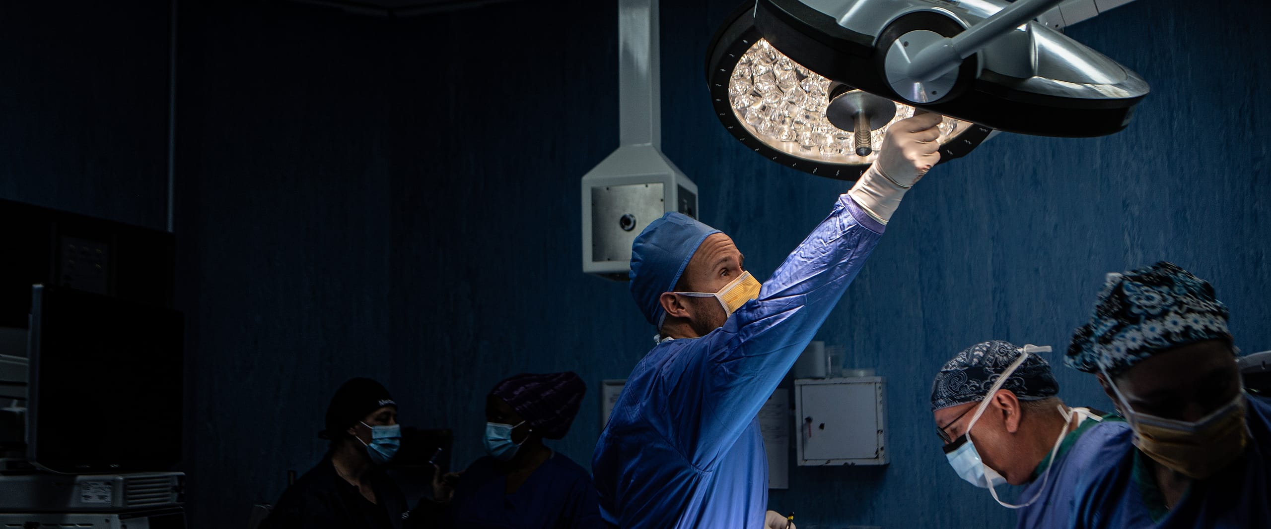 A surgeon positioning the operating light at the start of a procedure.