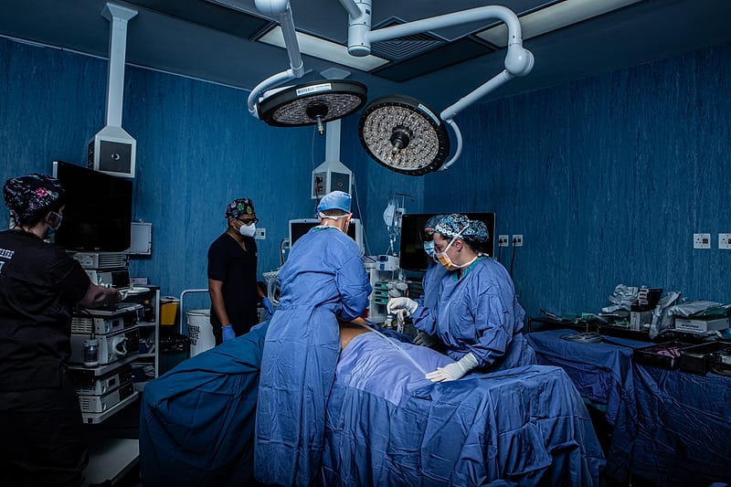 The full surgical team at work in theatre under the operating lights.