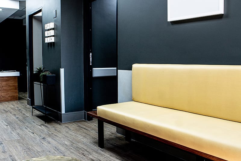 The long yellow bench outside the consulting rooms.