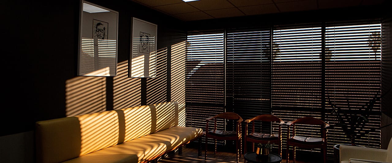 The Obesity Health Centre waiting room at the end of the day, sunlight falling in stripes across a long bench.